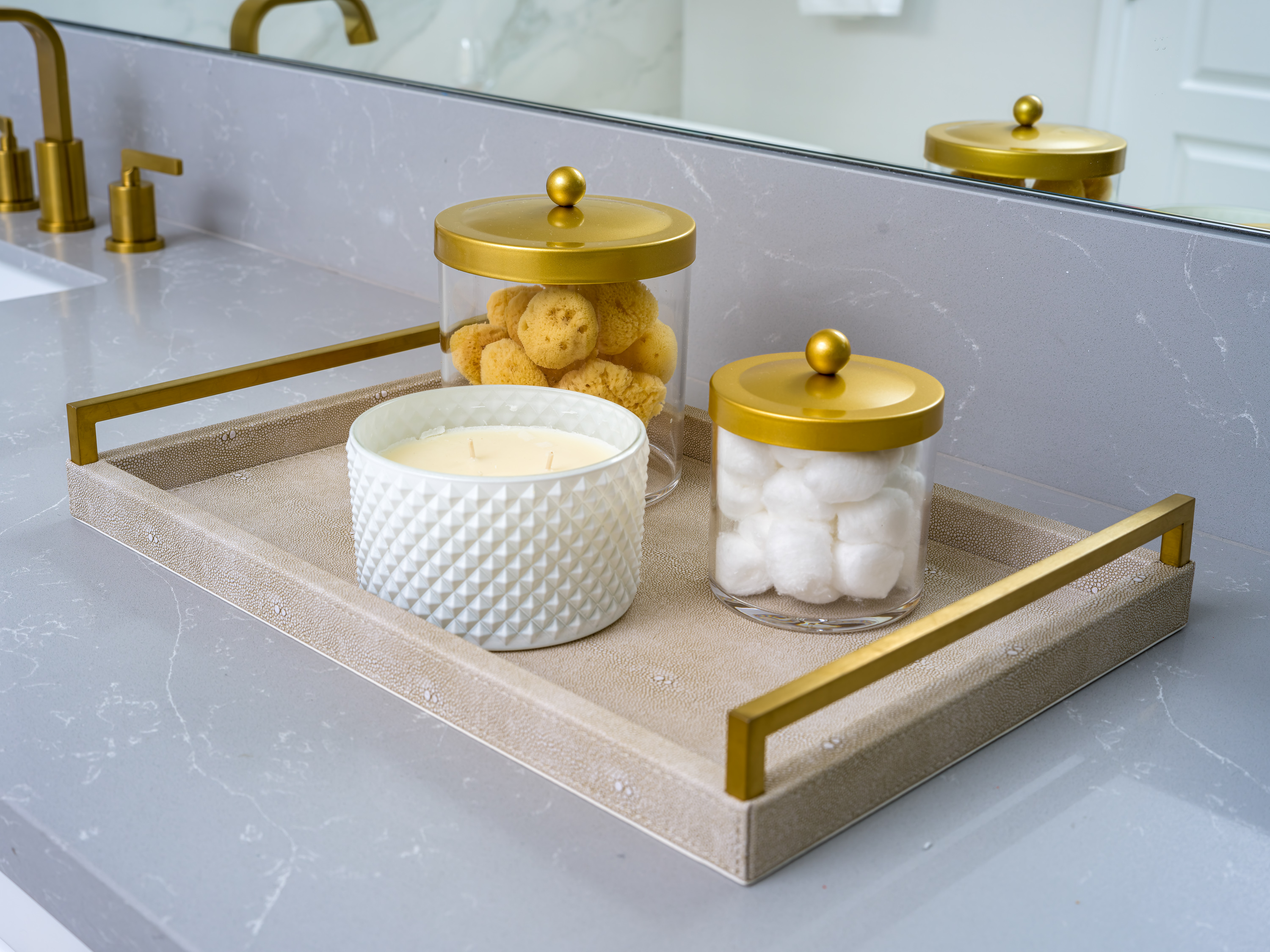 Vanity area with sophisticated bathroom accessories and cohesive gold design details.